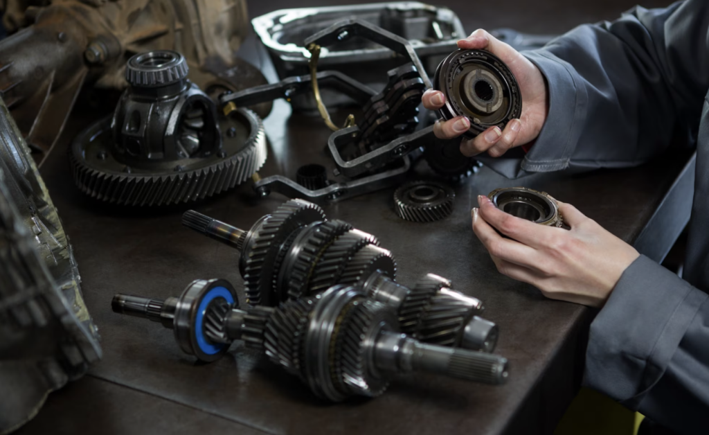 Female mechanic holding spare parts of car