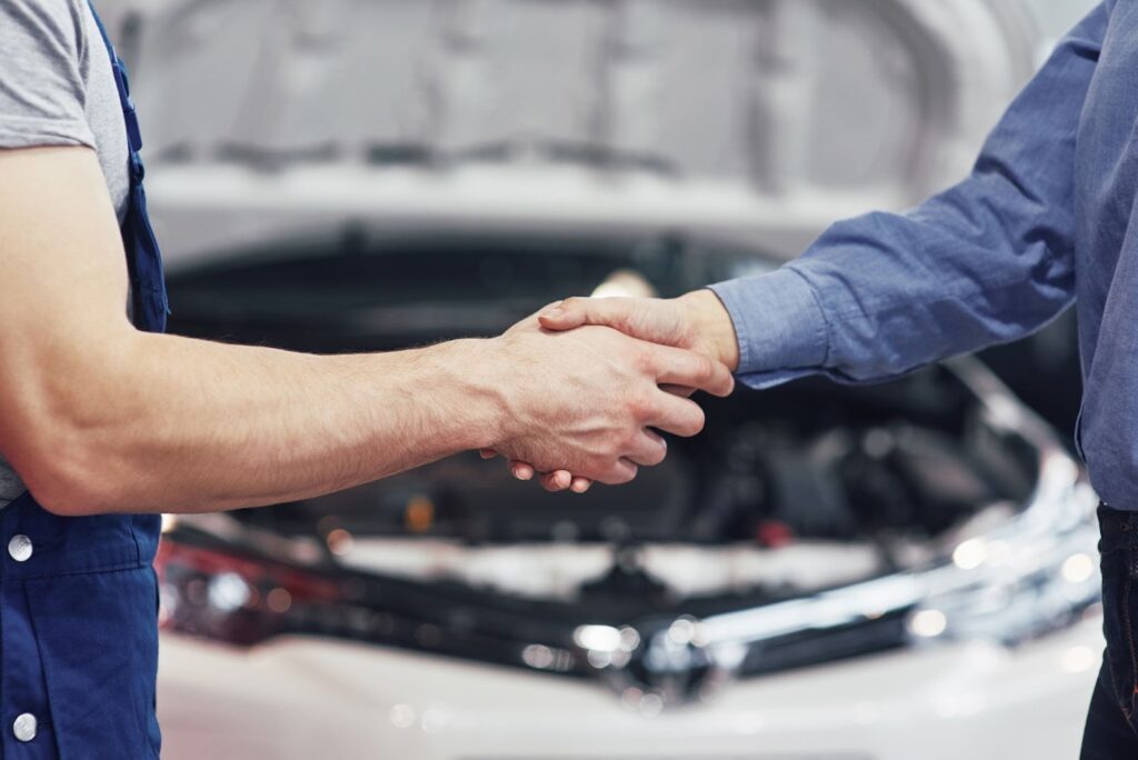 Mechanic and customer shaking hands