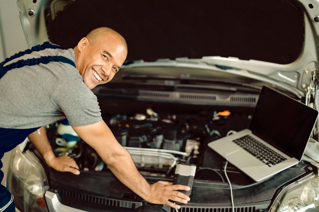 Happy mechanic fixing a car