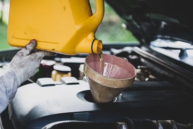 A man pours oil into the car
